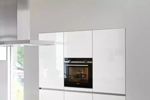 A HANDLELESS KITCHEN WITH COLOURFUL ELEMENTS: WHITE AND METAL